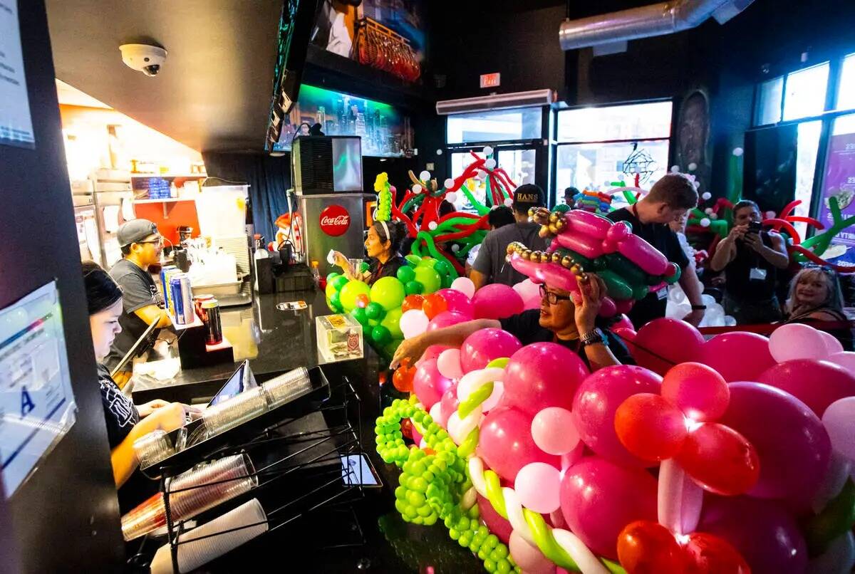 Los asistentes a la convención de globos Bling Bling Jam se detienen para tomar un refresco de ...