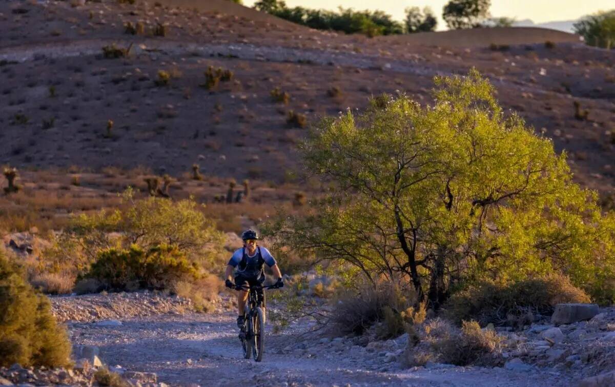 Nate Coats recorre un sendero en las colinas del suroeste mientras el sol se eleva sobre el val ...