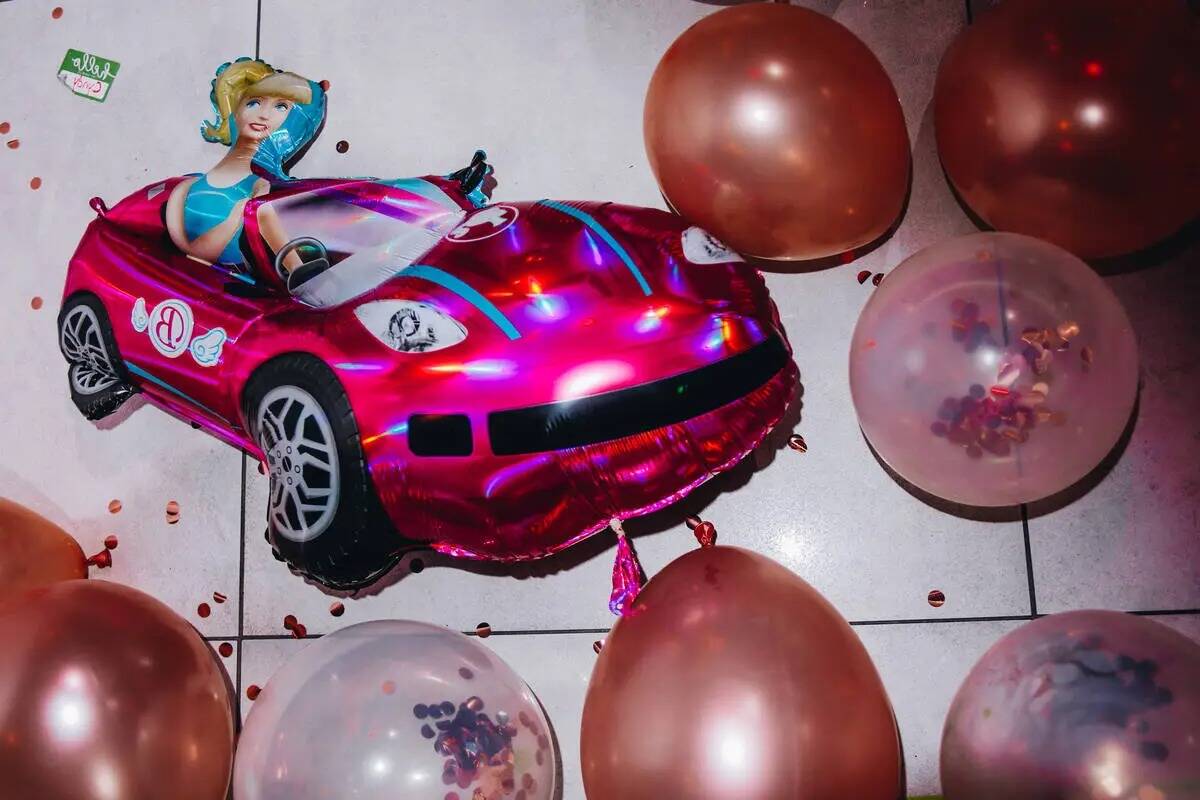 Un globo con la forma de Barbie en su convertible rosa se ve en el suelo en una fiesta de estre ...