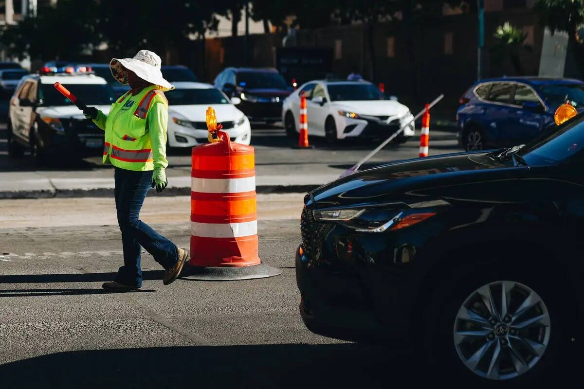 Una persona dirige el tránsito mientras la calle está en obras para el Grand Prix de Las Vega ...