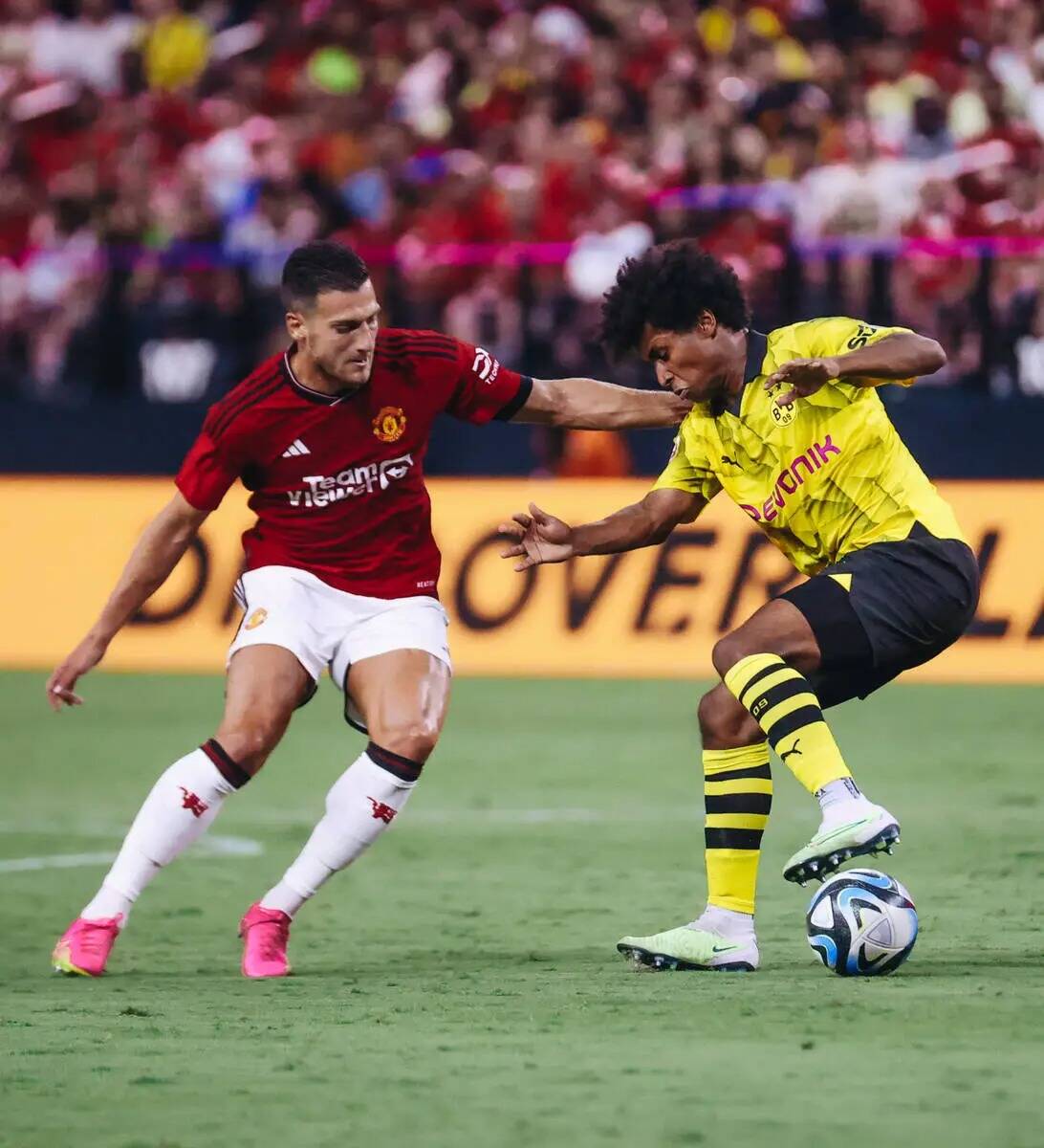 El delantero del Borussia Dortmund Karim Adeyemi (27) lucha por mantener el balón en su poder ...