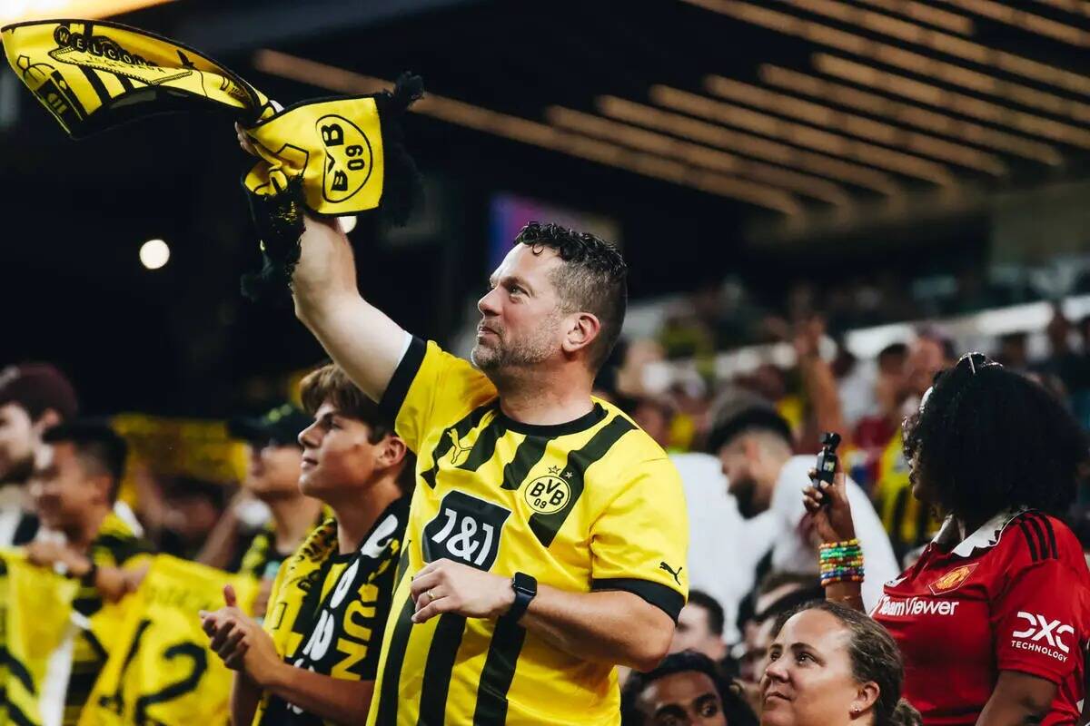 Un fan del Borussia Dortmund agita una bufanda en el aire para celebrar que su equipo anota un ...