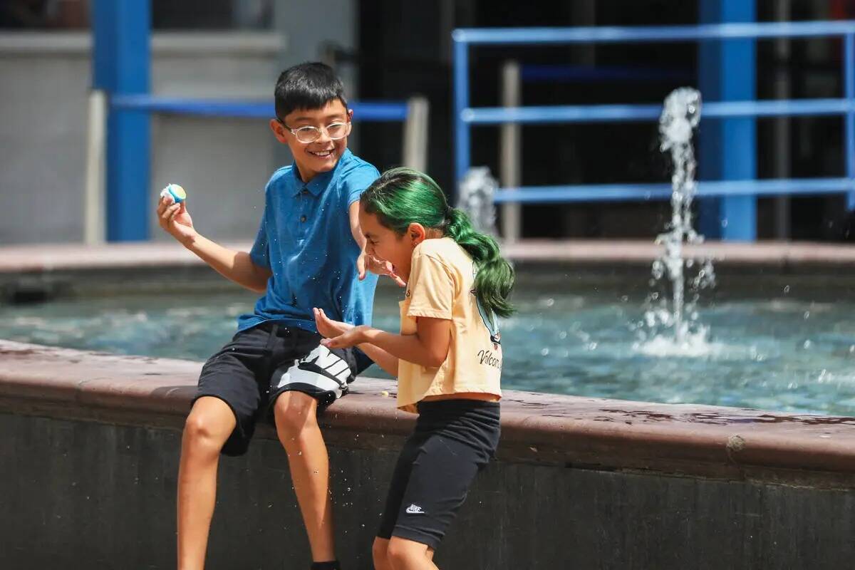 Unos niños intentan mantenerse frescos jugando en una fuente del Strip el lunes 31 de julio de ...