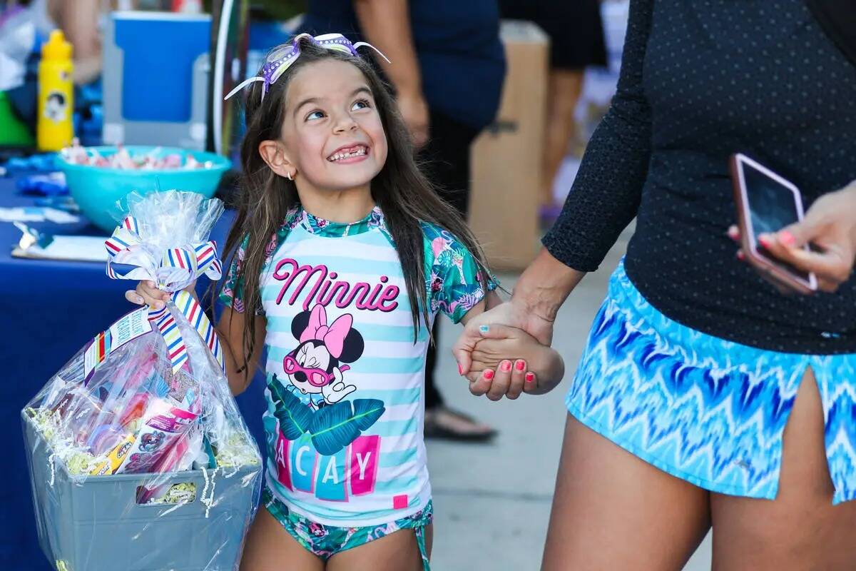 Lyanna S., de seis años, observa alegremente a su madre después de ganar un sorteo de materia ...