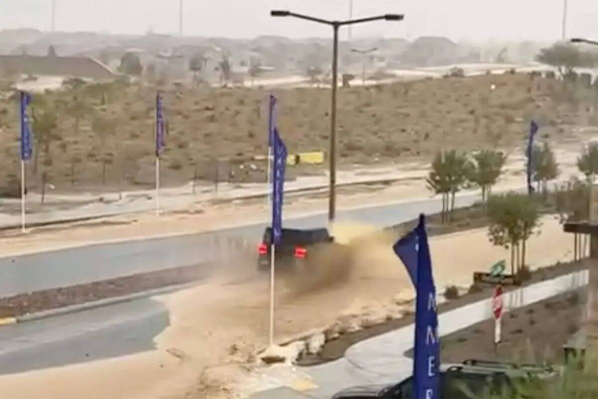 Un auto circula por una calle inundada en Summerlin West en medio de fuertes lluvias el martes ...