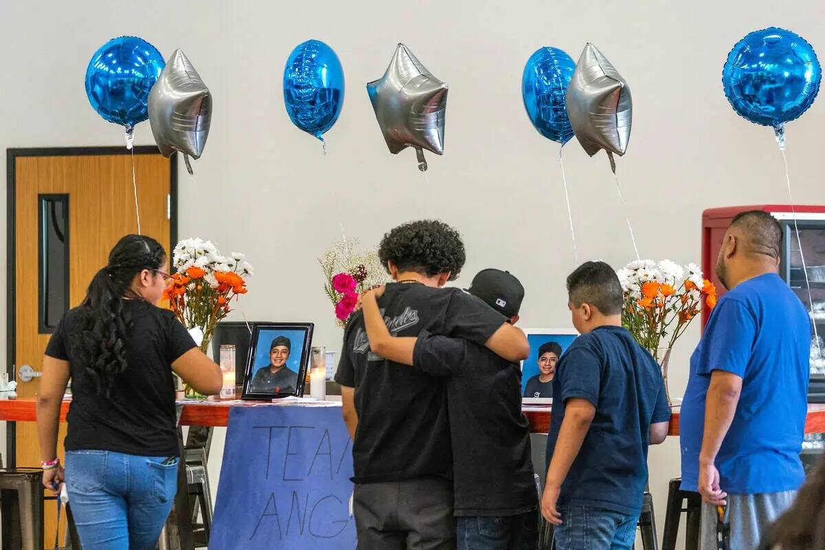 Familiares y amigos se sientan en una mesa conmemorativa de artículos de Ángel Naranjo durant ...