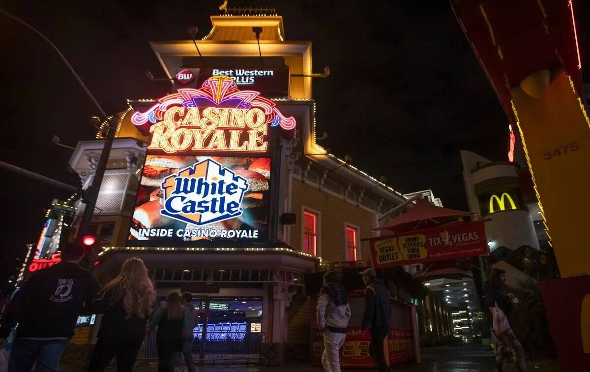 Un grupo de personas pasa por delante del Casino Royale en el Strip en marzo de 2020 en Las Veg ...