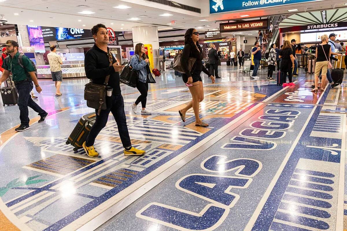 Los pasajeros que llegan se dirigen a la zona de reclamo de equipaje en la Terminal 1 del Aerop ...