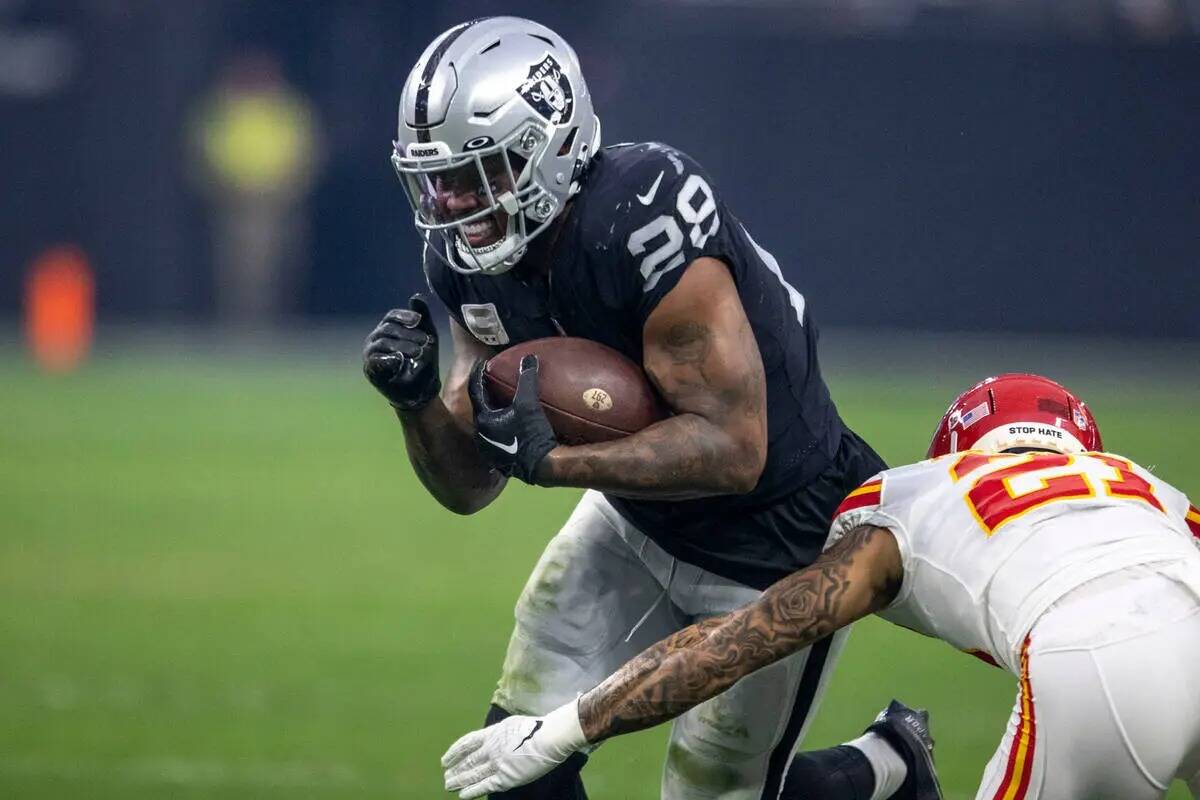 El running back de los Raiders Josh Jacobs (28) corre contra el cornerback de los Kansas City C ...