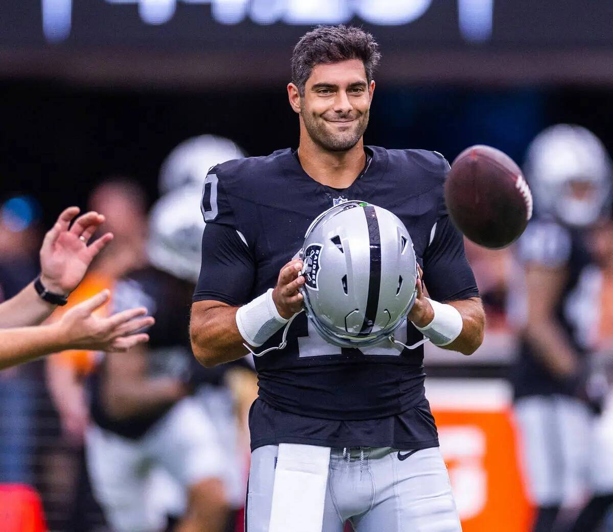 El quarterback de los Raiders Jimmy Garoppolo (10) observa y sonríe durante el calentamiento a ...