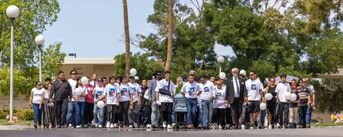 Rudolfo Naranjo llora mientras observa como el ataúd de su hijo Ángel es bajado a la tierra d ...