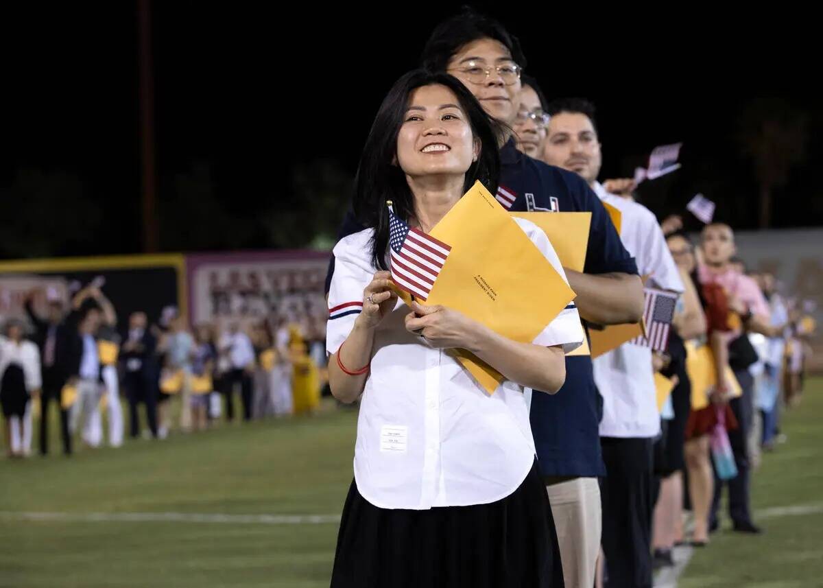 Nuevos ciudadanos de Estados Unidos sonríen durante su ceremonia de naturalización en el medi ...