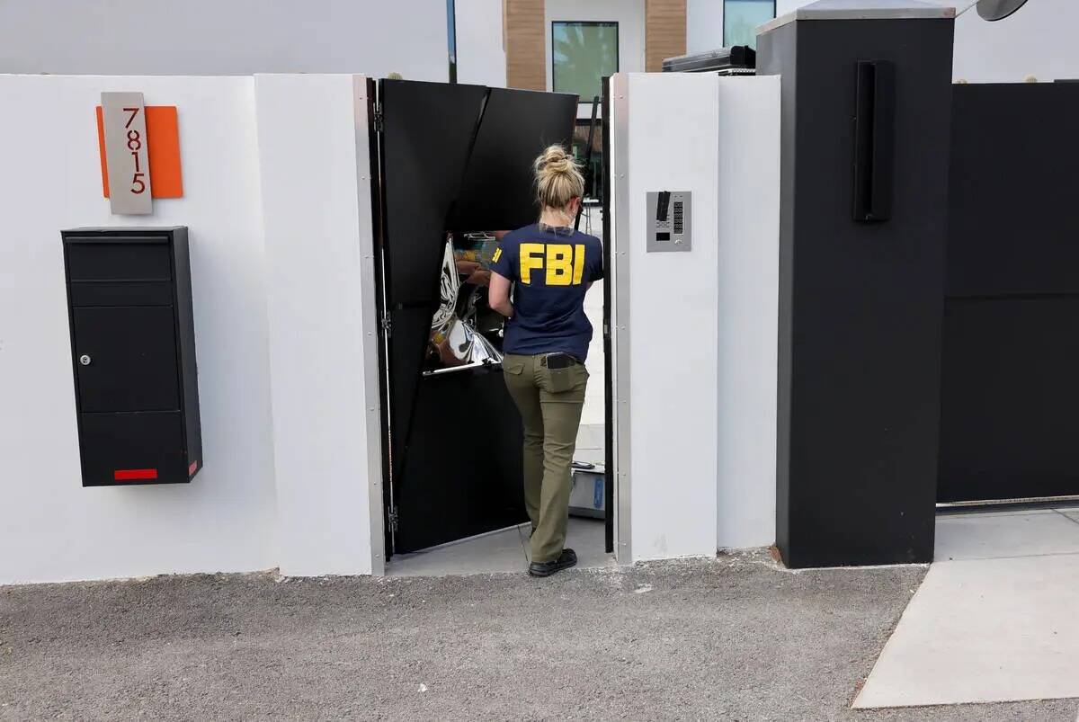 Personal del FBI investiga en una casa en la esquina de West La Madre Way y Conough Lane en Las ...
