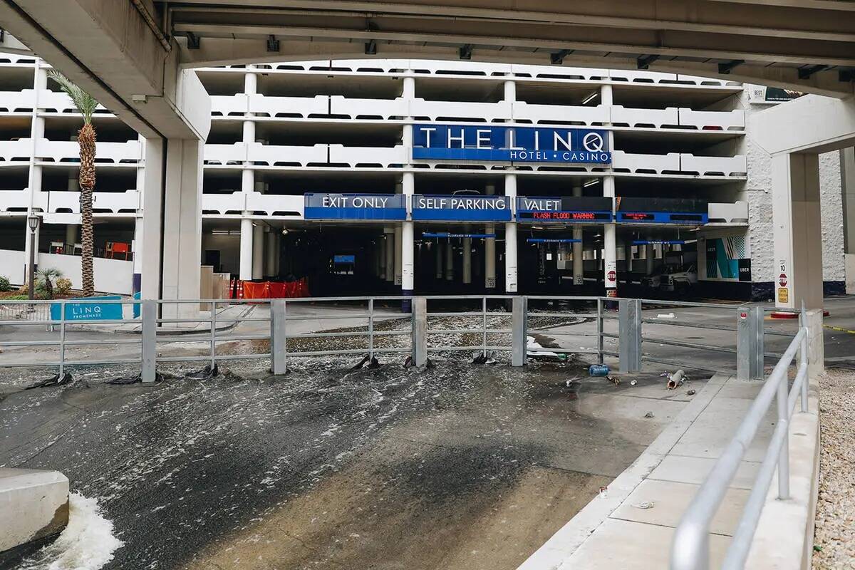 El agua fluye hacia un canal de inundación desde el estacionamiento de The Linq el domingo 20 ...