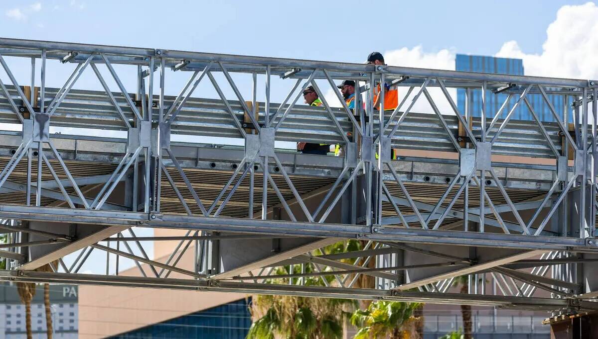Trabajadores caminan mientras Las Vegas Grand Prix, Inc. da una vista previa de los puentes veh ...