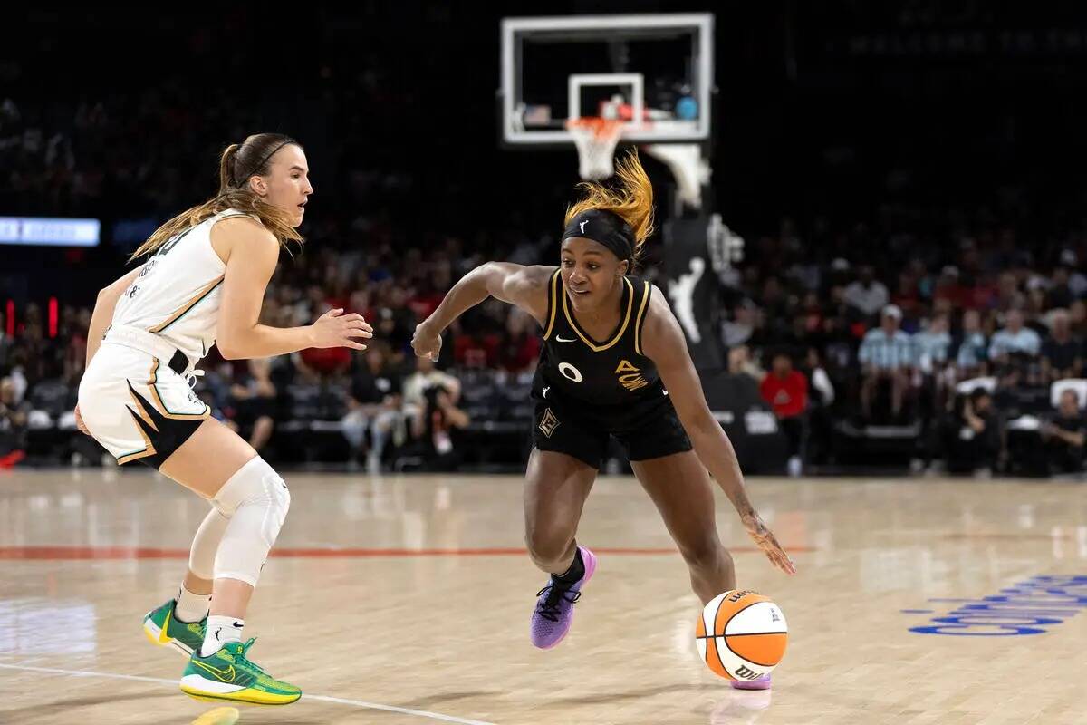 La escolta de las Aces Jackie Young driblea mientras la escolta de las New York Liberty Sabrina ...