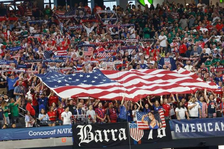 Fanáticos de Estados Unidos sostienen banderas estadounidenses antes de un partido de fútbol ...