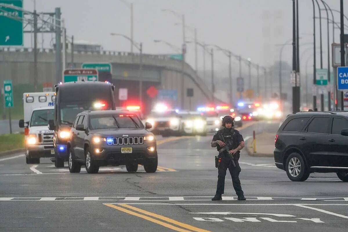 Un agente de policía se para en la carretera mientras una caravana del expresidente Donald Tru ...