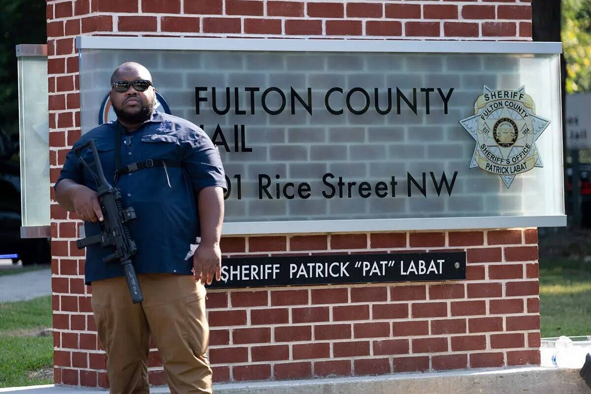 Un funcionario monta guardia frente a la cárcel del Condado Fulton, en Atlanta, el jueves 24 d ...