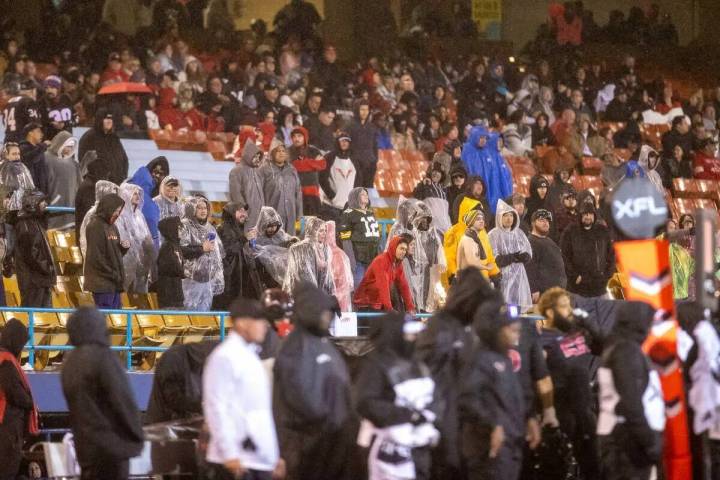 Los fans se enfrentan a la lluvia durante la segunda parte de un partido de fútbol americano d ...