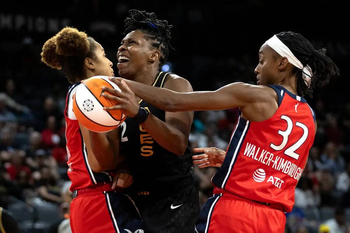 La escolta de Las Vegas Aces Chelsea Gray (12) lucha por anotar contra la alera de Washington M ...