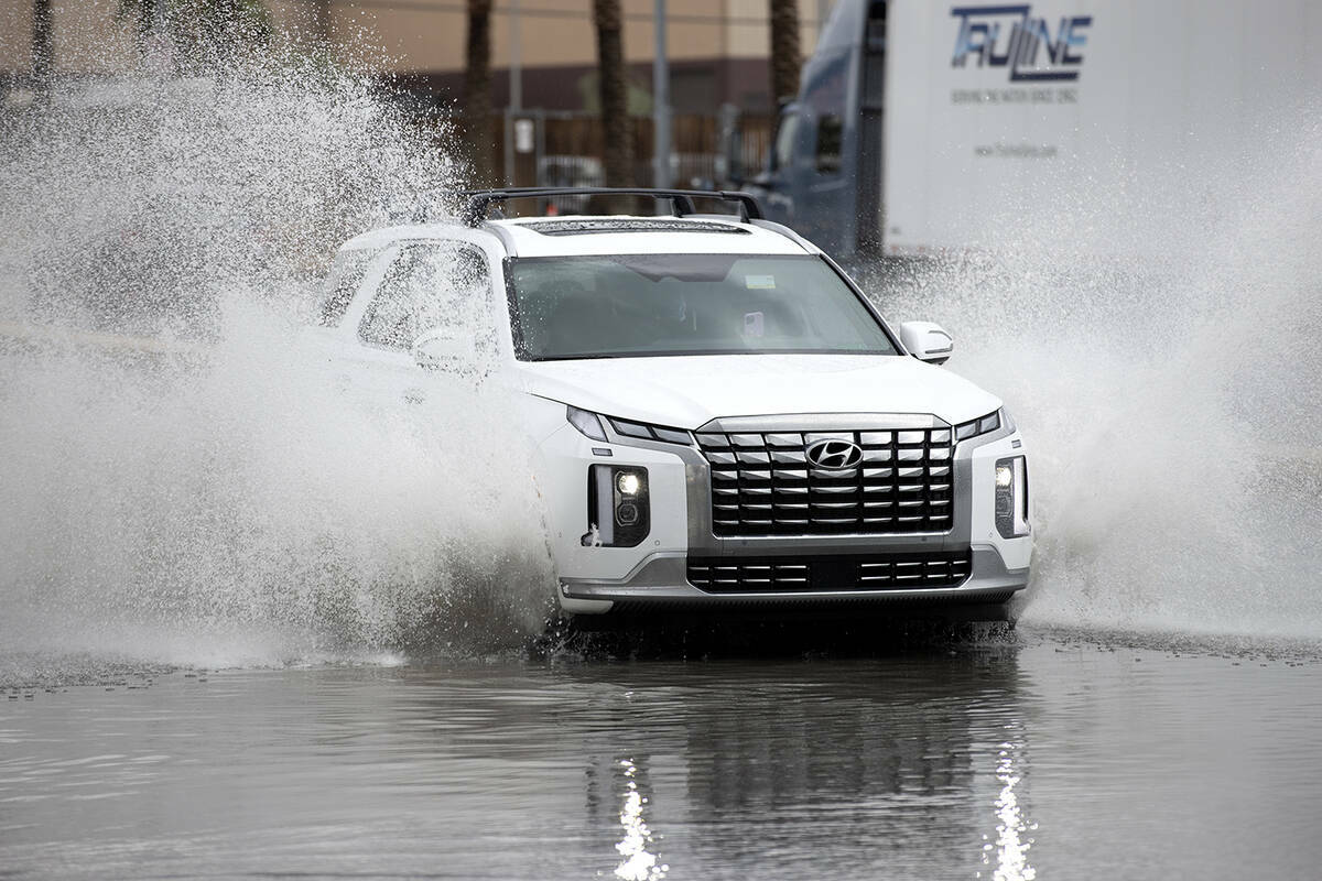 Un vehículo pasa a través de las aguas de la inundación en West Russell Road y Polaris Avenu ...