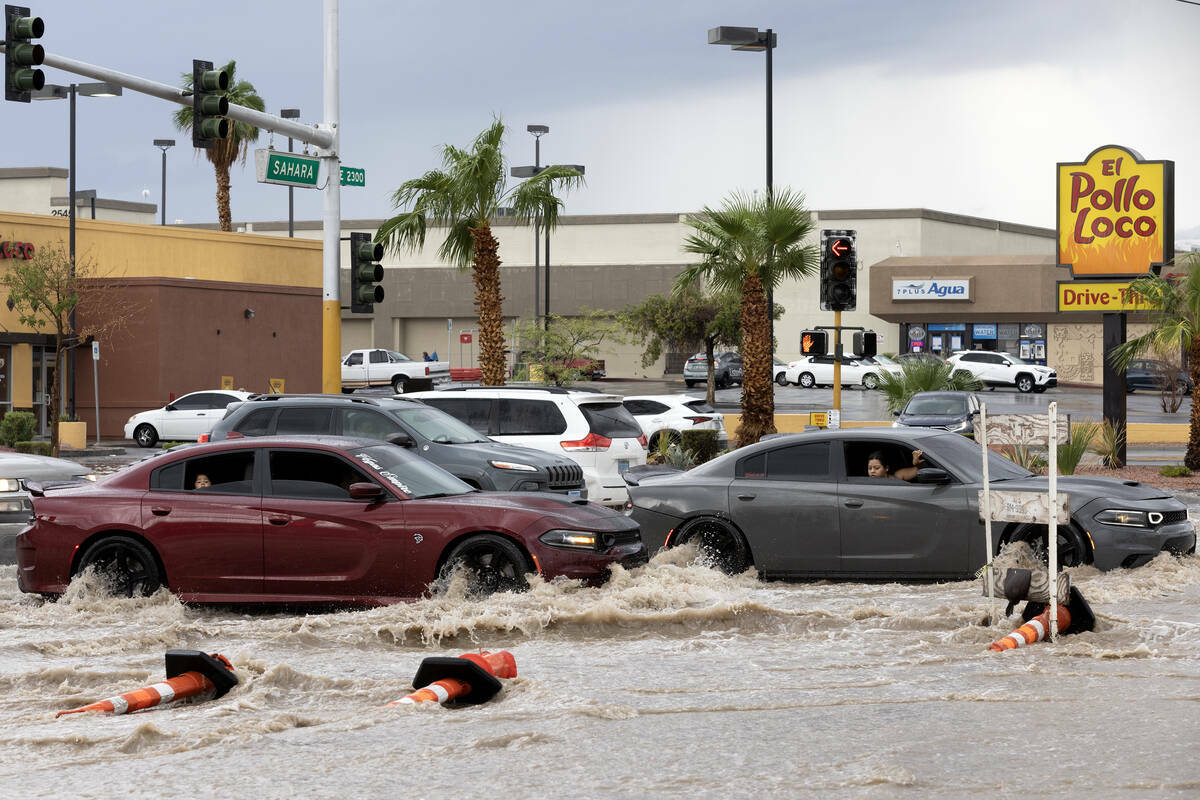 Automovilistas observan las aguas de inundación repentina a su paso por East Sahara Avenue y S ...