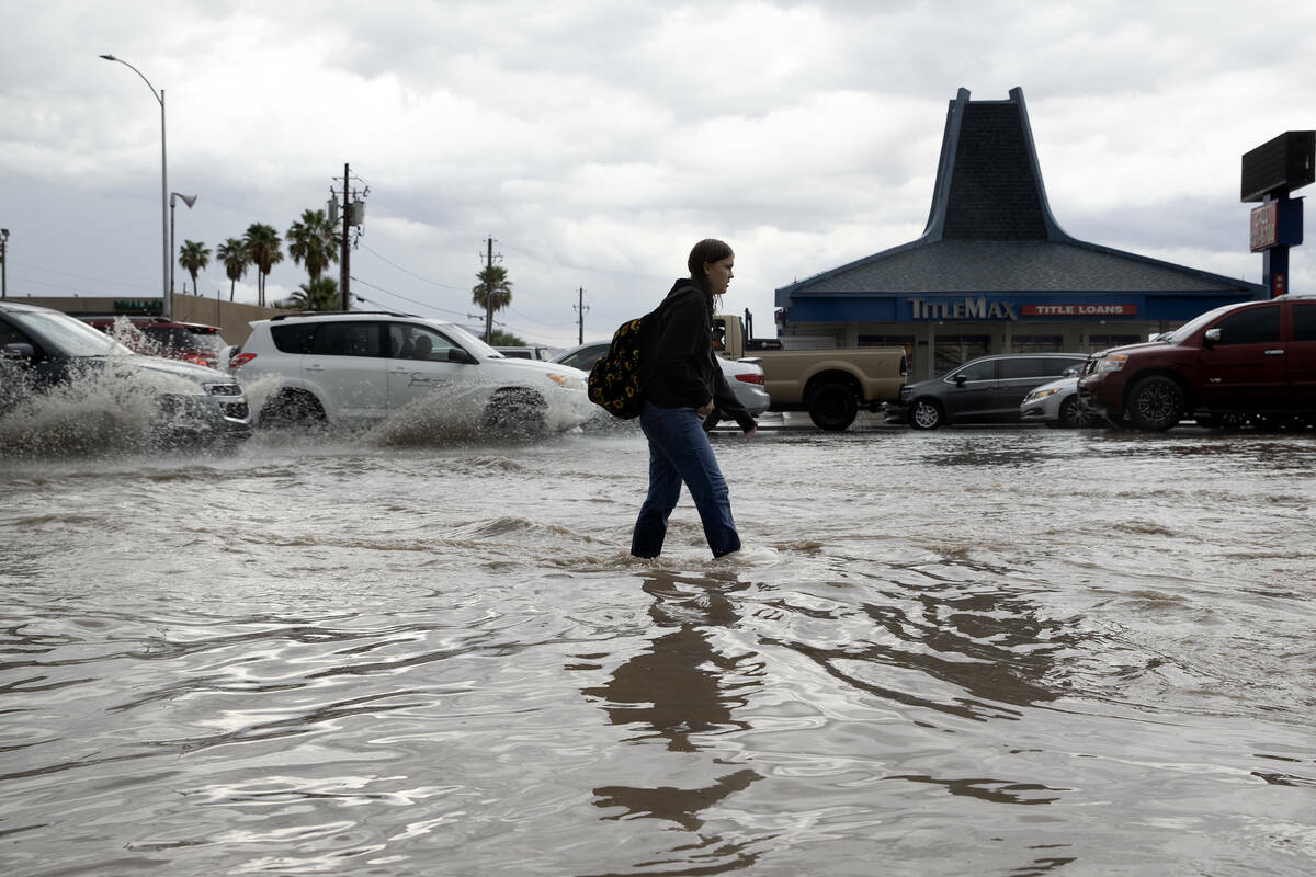 Una mujer camina por una acera inundada en South Eastern Avenue, el viernes 1 de septiembre de ...