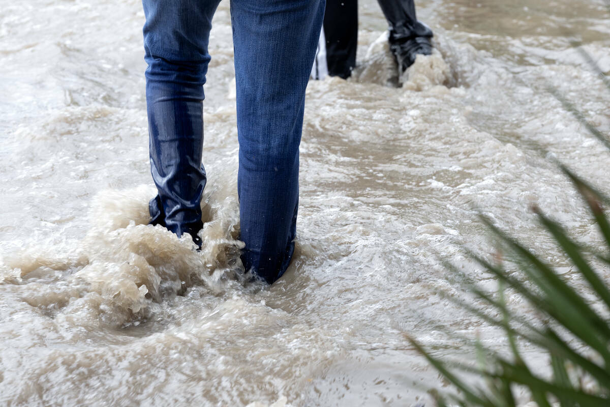 Peatones caminan por las aceras inundadas en South Eastern Avenue, el viernes 1 de septiembre d ...