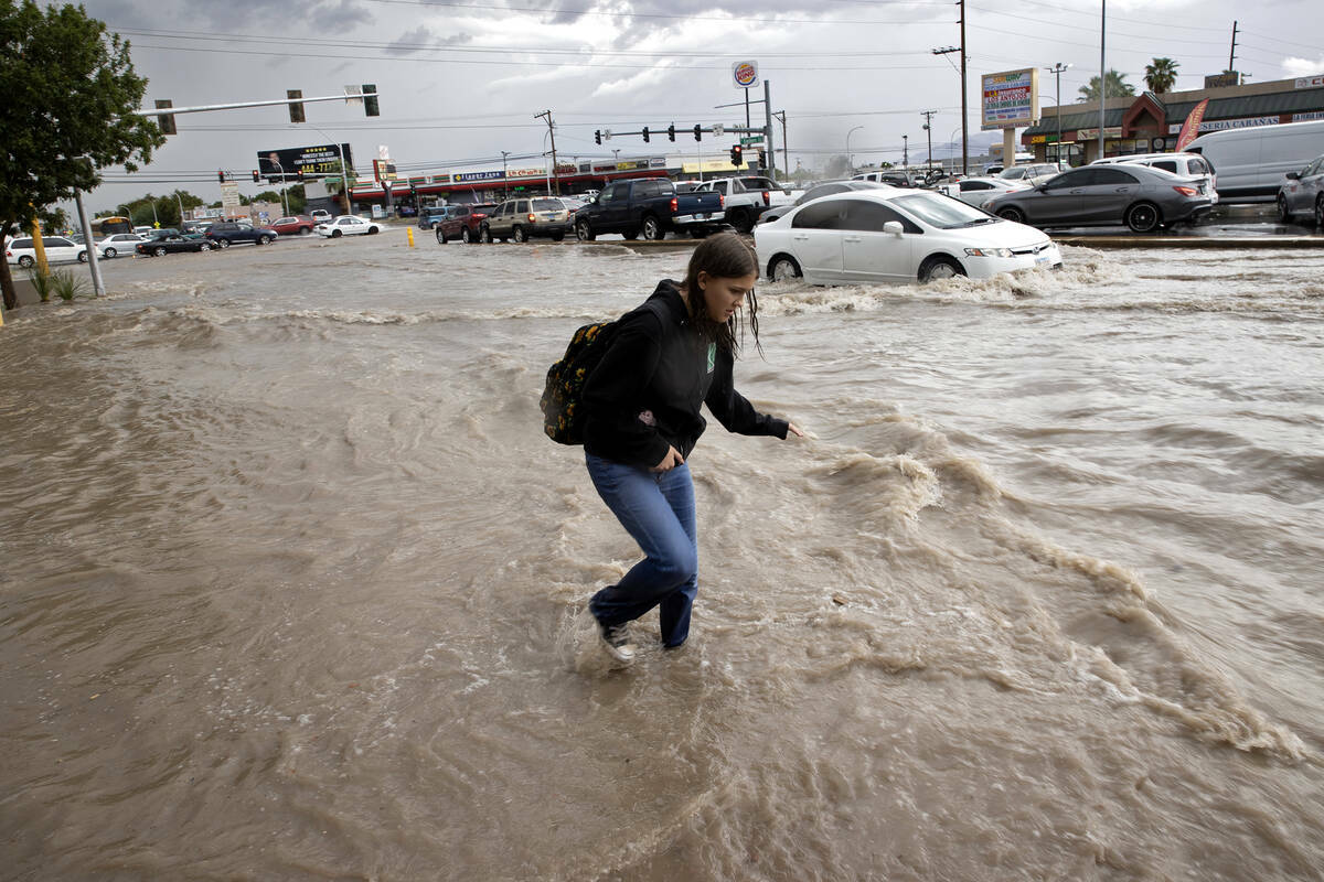Una mujer camina por una acera inundada en South Eastern Avenue, el viernes 1 de septiembre de ...