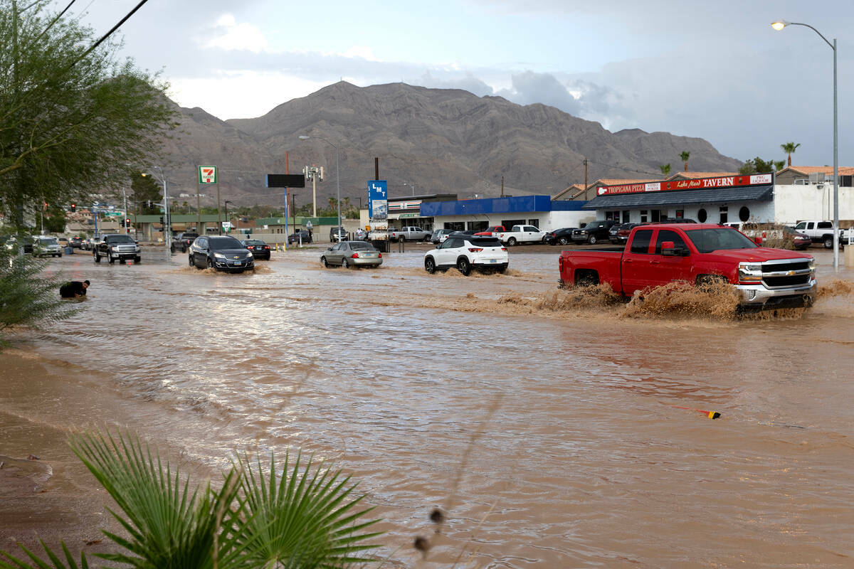 El tráfico avanza a través de una inundación repentina en East Lake Mead Boulevard, el sába ...
