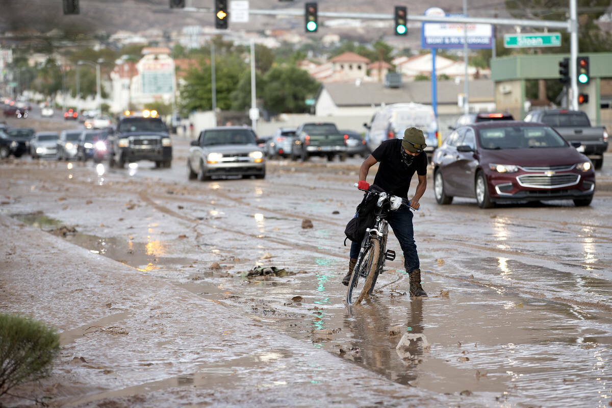 Un ciclista navega por caminos fangosos por East Lake Mead Boulevard, el sábado 2 de septiembr ...
