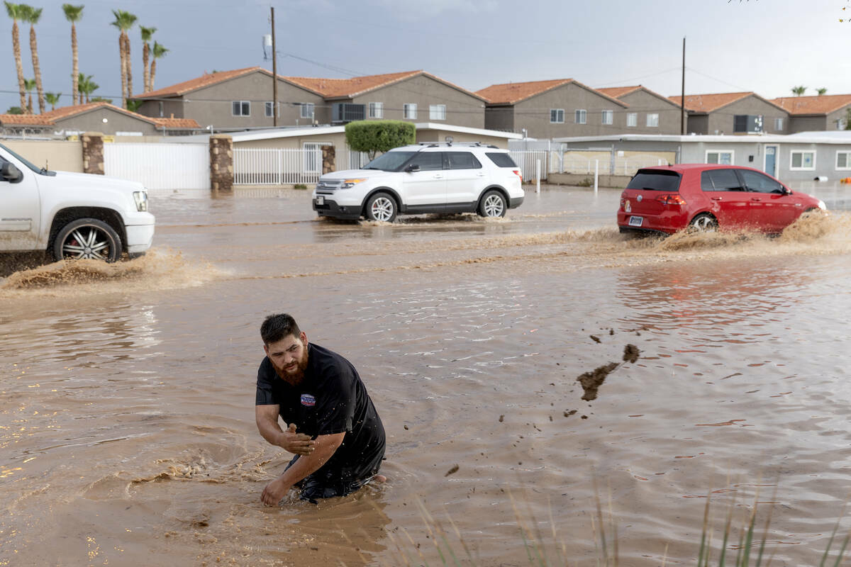 Tim Williams, habitante del vecindario, retira escombros de un desagüe pluvial, el sábado 2 d ...