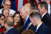 El presidente Joe Biden se hace una foto con un asistente después de hablar sobre la reducció ...