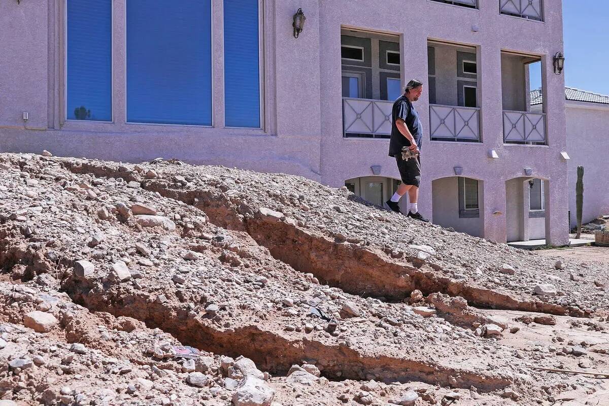 Dan Carmany se encuentra en la parte superior de un sumidero en su patio trasero que fue causad ...