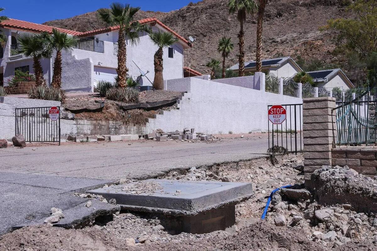 Parte de una carretera y un muro residencial destruidos tras las inundaciones repentinas que as ...