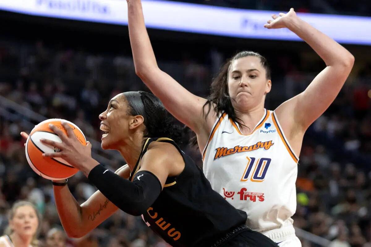 La alera de Las Vegas Aces A'ja Wilson (22) lucha hacia el aro contra la pívot de Phoenix Merc ...