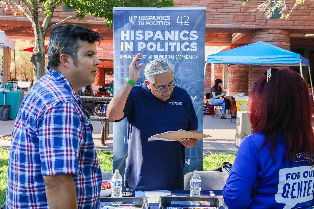 Jacinto Alfaro, a la izquierda, habla con Fernando Romero en un stand de Hispanics in Politics ...