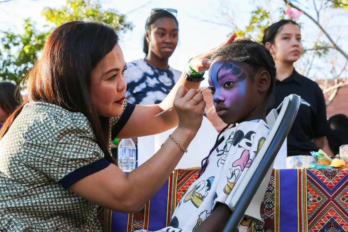 Herden Guevrra pinta la cara de Jaeda Williams en el Communities United, Raising The Stakes Mul ...