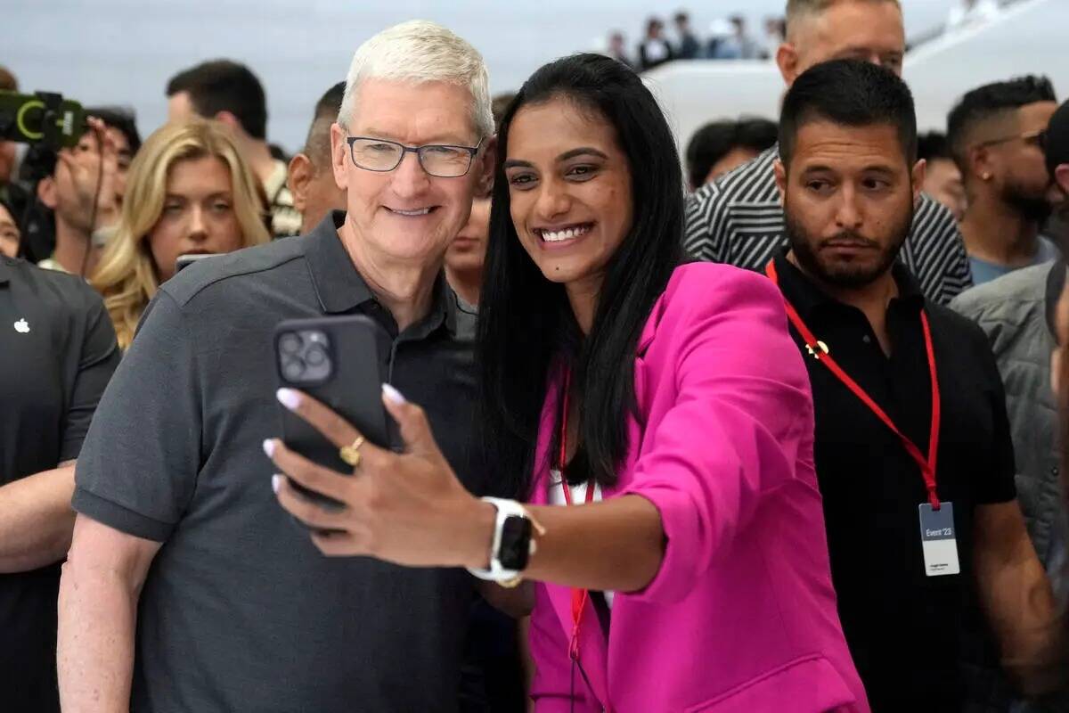El director ejecutivo de Apple, Tim Cook, posa para una selfie con la jugadora india de bádmin ...