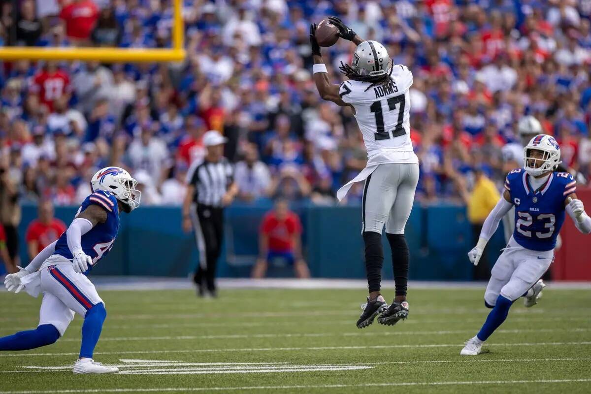 El wide receiver de los Raiders Davante Adams (17) hace una atrapada de salto con el safety de ...
