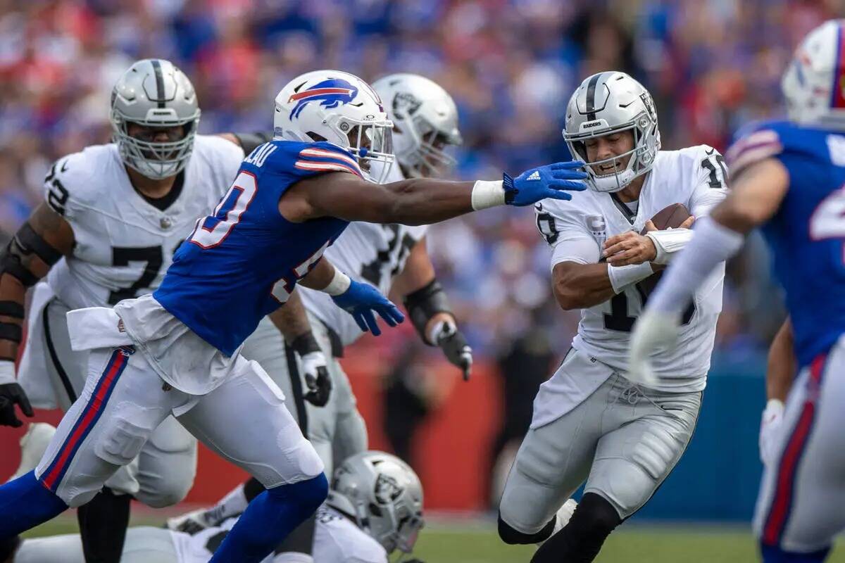 El quarterback de los Raiders Jimmy Garoppolo (10) se aferra al fútbol americano mientras el d ...