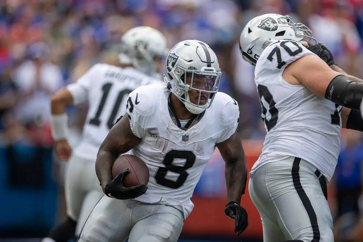 El running back de los Raiders Josh Jacobs (8) busca espacio para correr contra los Buffalo Bil ...