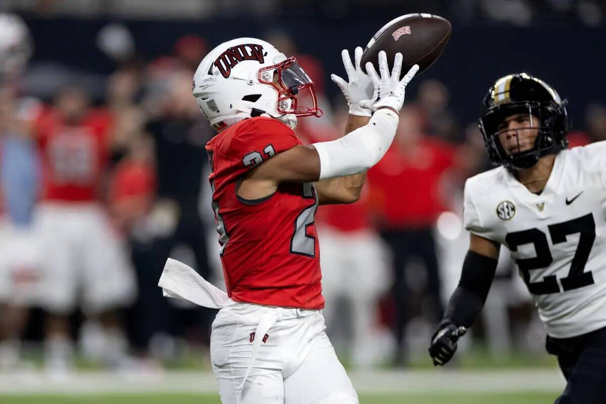 El wide receiver de UNLV Jacob De Jesus (21) atrapa un pase largo antes de correr para un touch ...