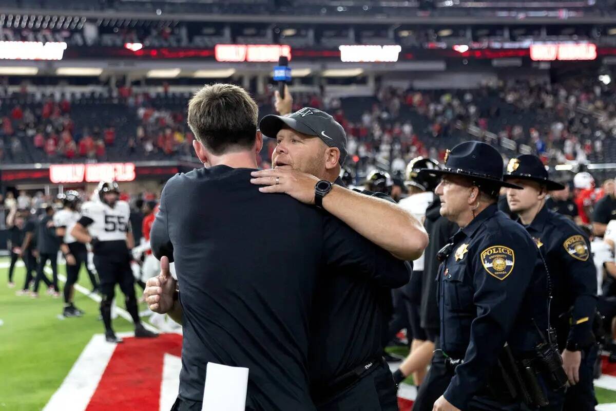 El entrenador de la UNLV, Barry Odom, abraza a un compañero después de que su equipo ganara u ...