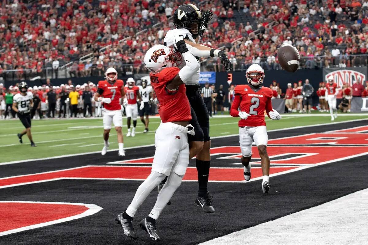 El defensive back de UNLV Jerrae Williams (1) detiene una captura de touchdown del tight end de ...