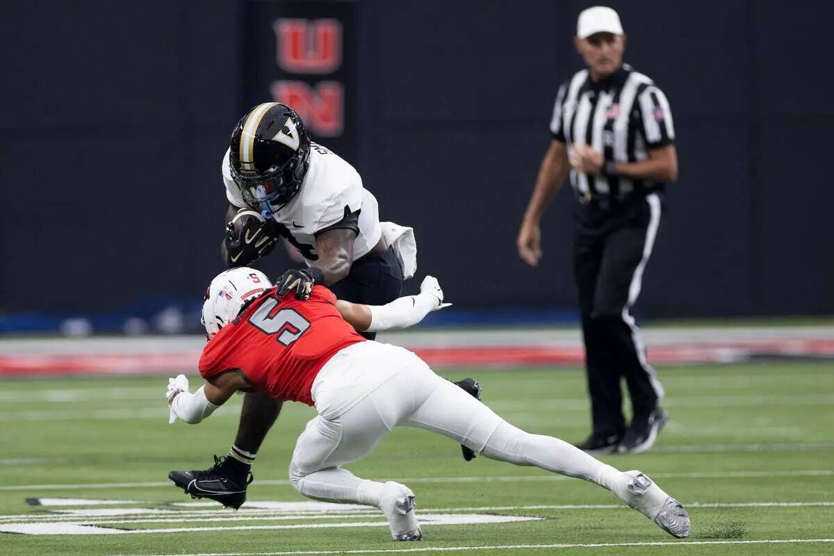 El defensive back de UNLV Cameron Oliver (5) taclea al running back de Vanderbilt Patrick Smith ...