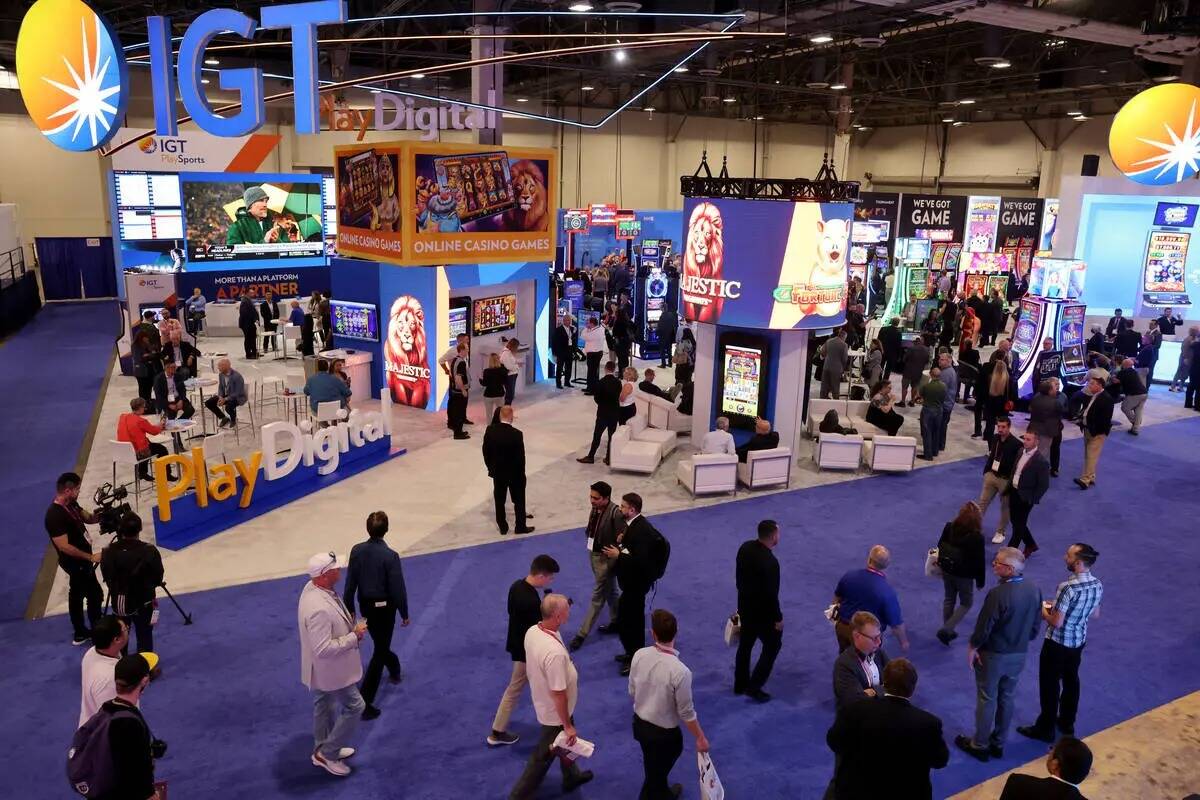 Convencionistas caminan a través de la exhibición de International Game Technology durante G2 ...