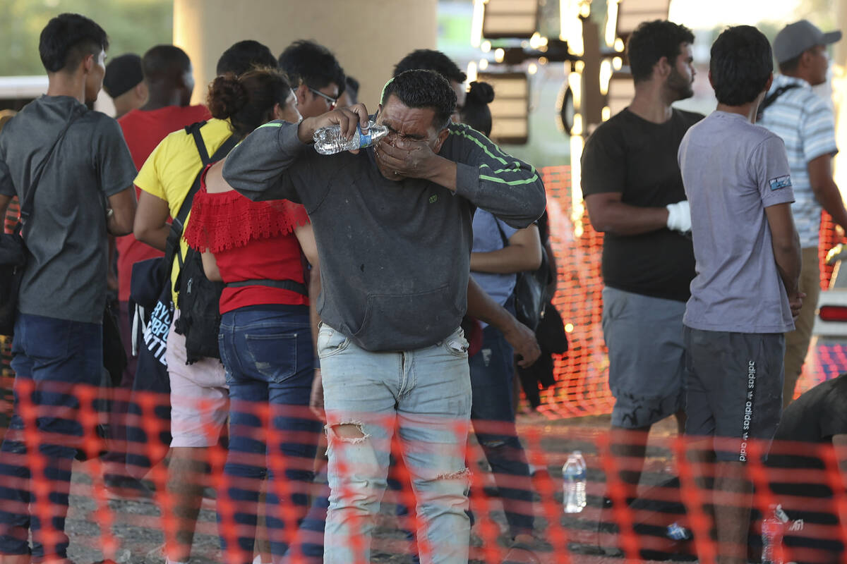Un migrante se lava la cara en un centro de procesamiento de la Patrulla Fronteriza de Estados ...