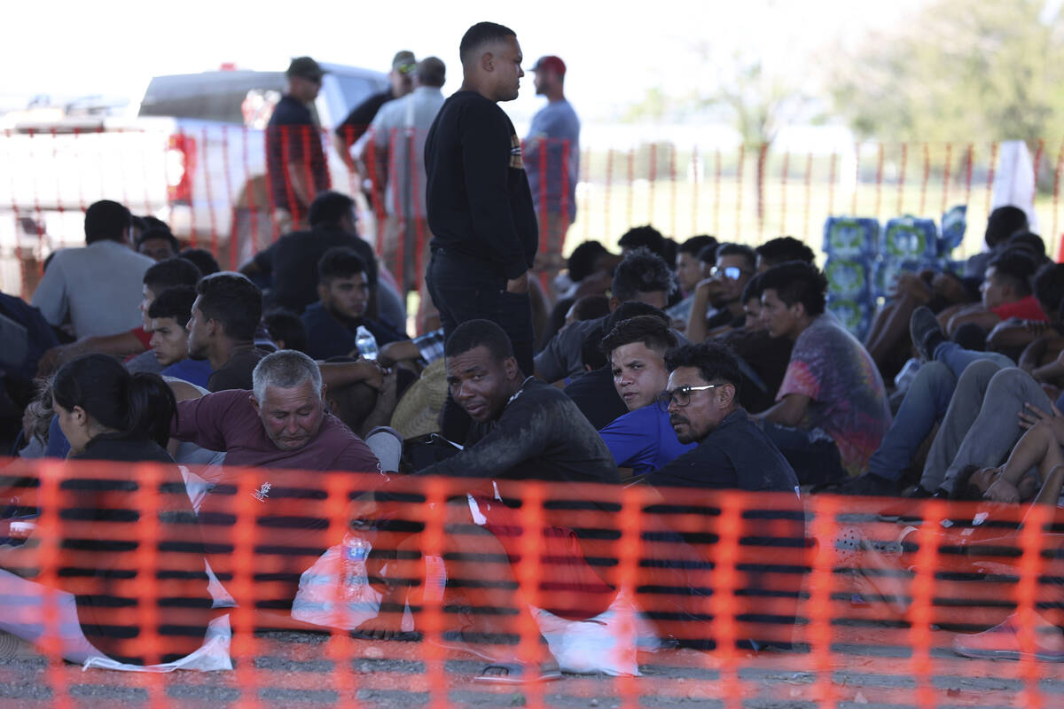 Agentes de la Patrulla Fronteriza de Estados Unidos procesan a cientos de migrantes bajo el Pue ...